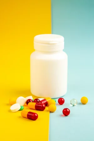 front-view-different-pills-with-plastic-flask-yellow-blue-background-health-lab-science-hospital-covid-pandemic-color-drug-virus front-view-different-pills-with-plastic-flask-yellow-blue-background-health-lab-science-hospital-covid-pandemic-color-drug-virus